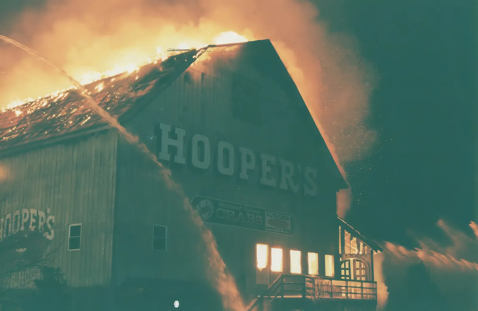 Hooper's Crab House engulfed in flames during the 2002 fire, with the lit HOOPER'S sign still visible on the building