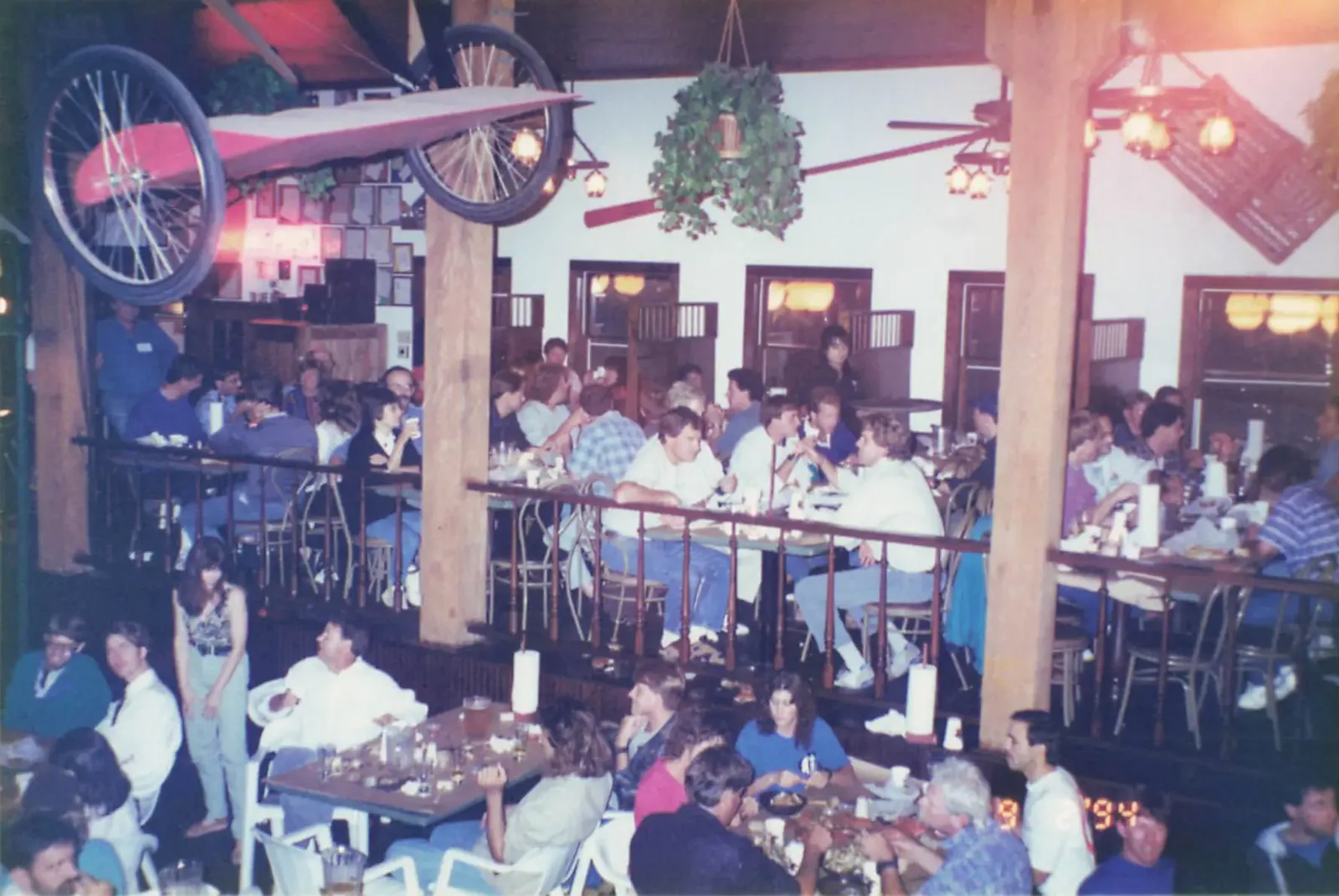 A packed Hooper's Crab House dining room full of guests in 1994, with a vintage airplane mounted on the wall